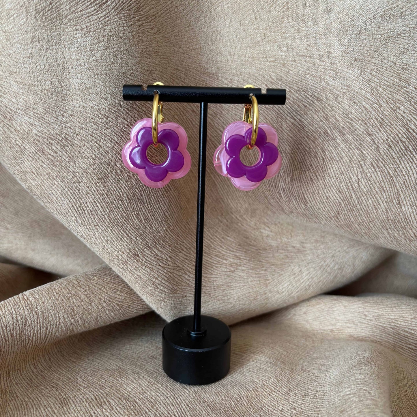 Petites boucles d'oreilles créoles dorées avec fleur violettes vendues sur le site internet prêtes à briller