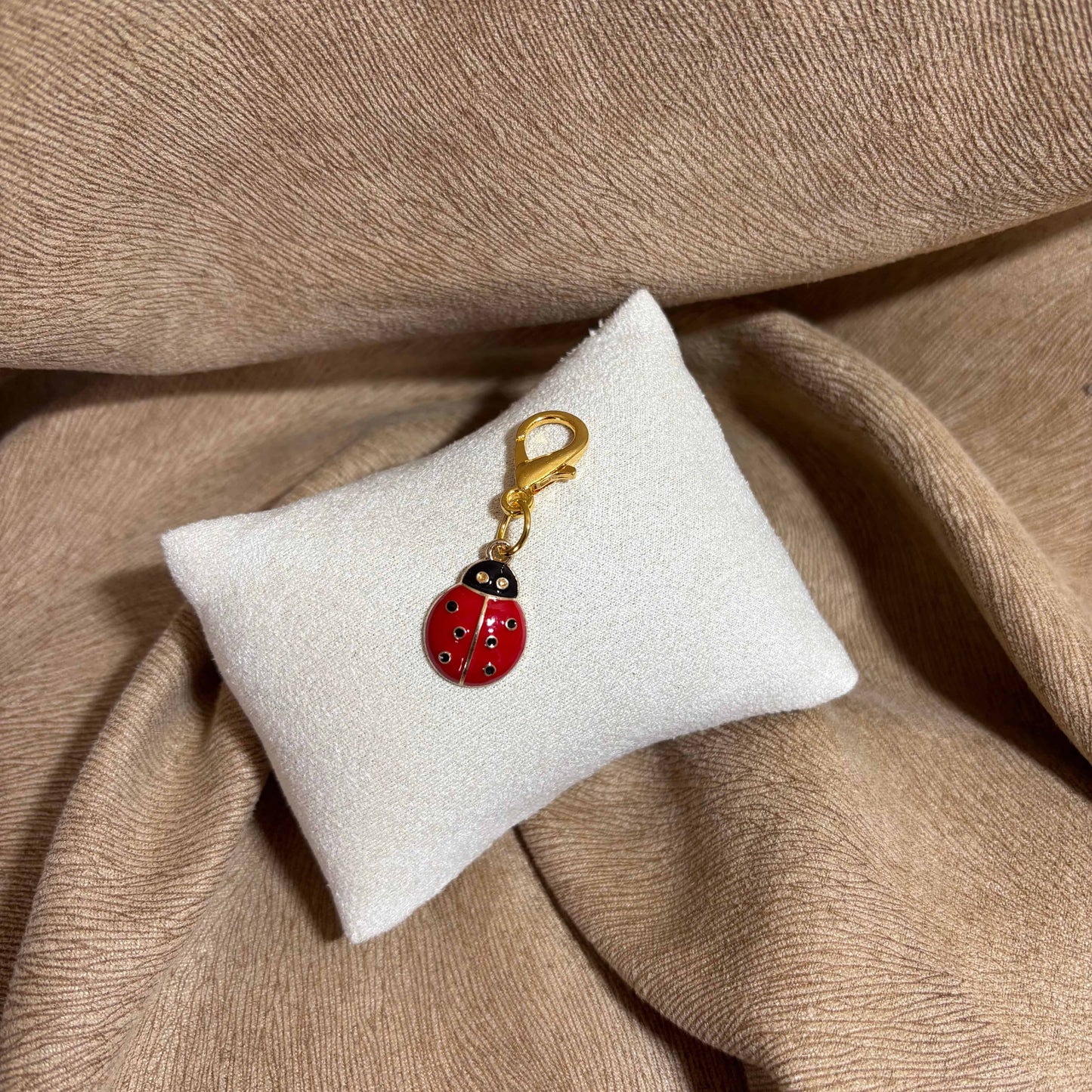 Bijou à accrocher doré avec breloque coccinelle rouge à pois noir vendu sur le site internet prêtes à briller