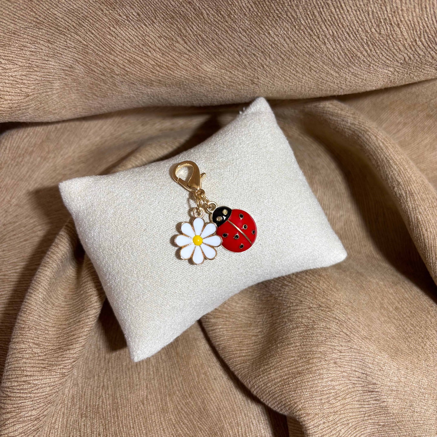 Bijou à accrocher avec attache dorée et breloque coccinelle et marguerite vendu sur le site internet prêtes à briller