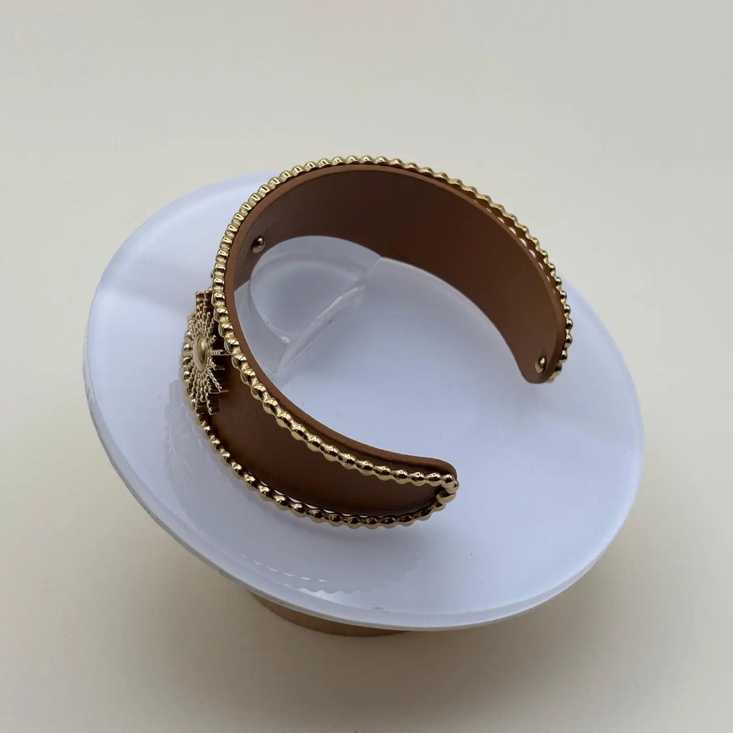 Vue intérieure d'un bracelet rigide ouvert marron avec fleurs dorées et perles dorées