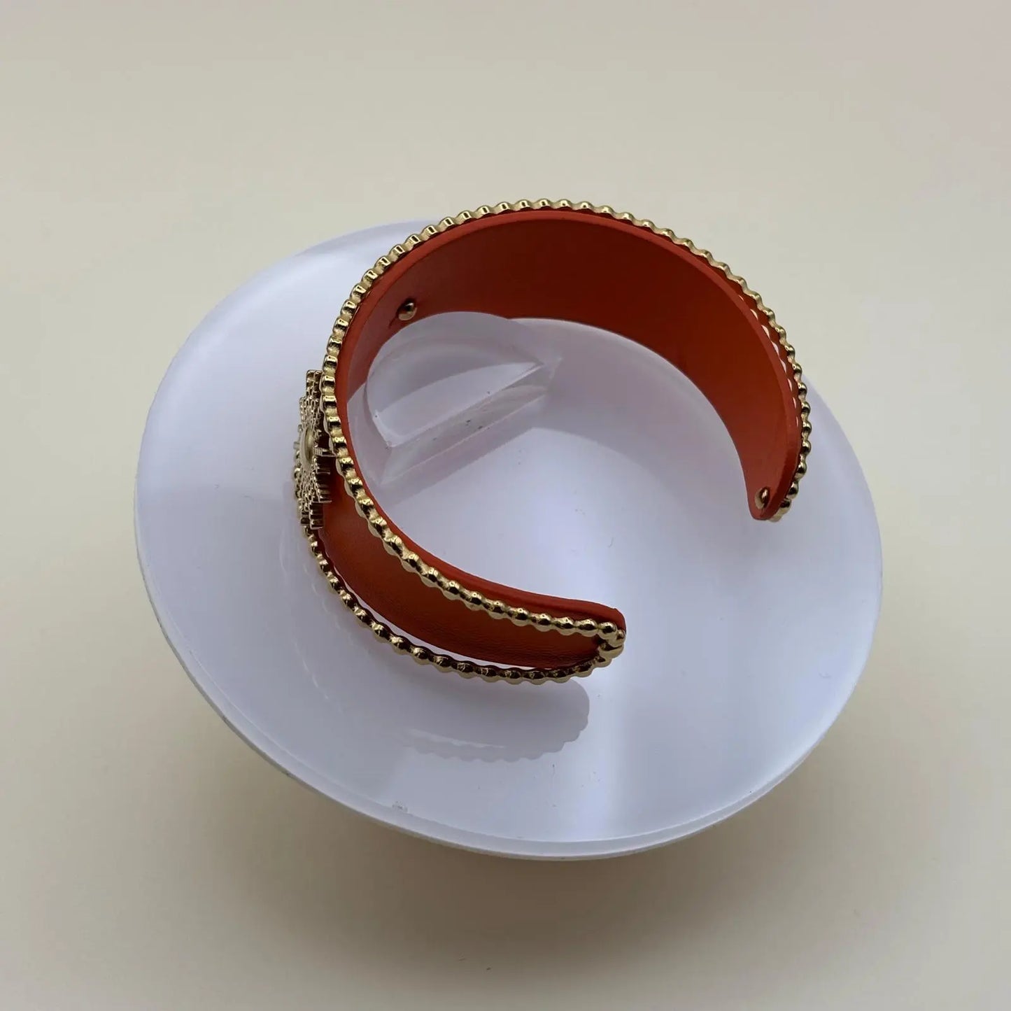 Vue intérieure d'un bracelet rigide ouvert marron avec fleurs dorées et perles dorées