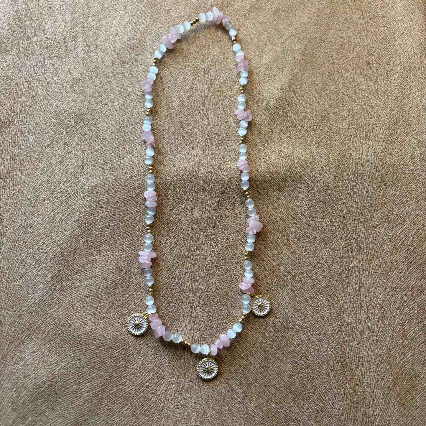 Collier artisanal en perles rose et blanches avec pendentifs décoratifs en forme de soleil bijou vendu sur le site internet prêtes à briller
