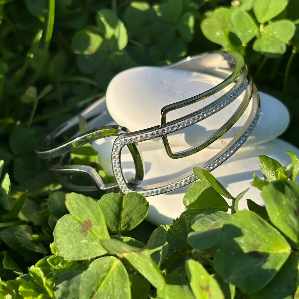 Gros plan sur les mains d'une femme métisse tenant un livre avec la couverture vert pale à la main, elle porte un bracelet argente Image