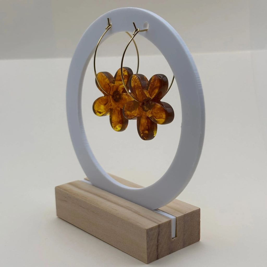 Une paire de boucles d’oreilles en résine en forme de fleurs couleur ambre