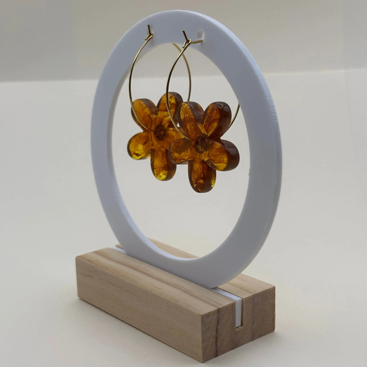 Une paire de boucles d’oreilles en résine en forme de fleurs couleur ambre