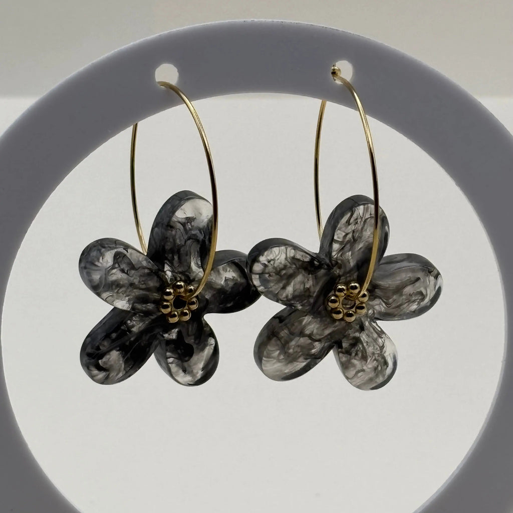 Des boucles d’oreilles en résine en forme de fleurs couleur noires 
