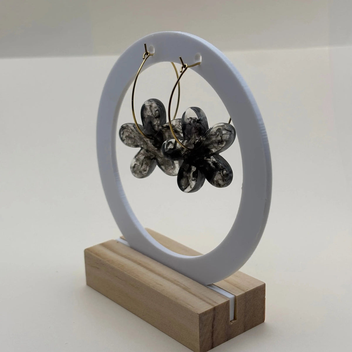 Une paire de boucles d’oreilles en résine en forme de fleurs couleur noires