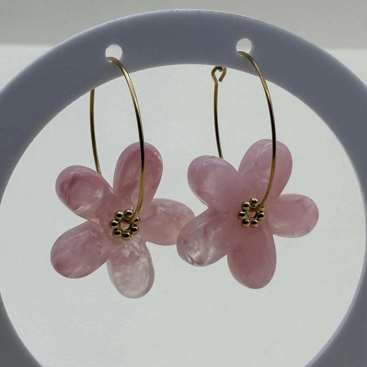 Des boucles d’oreilles en résine en forme de fleurs couleur rose