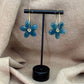 Boucles d’oreilles en résine en forme de fleurs couleur turquoise sur le site internet prêtes à briller