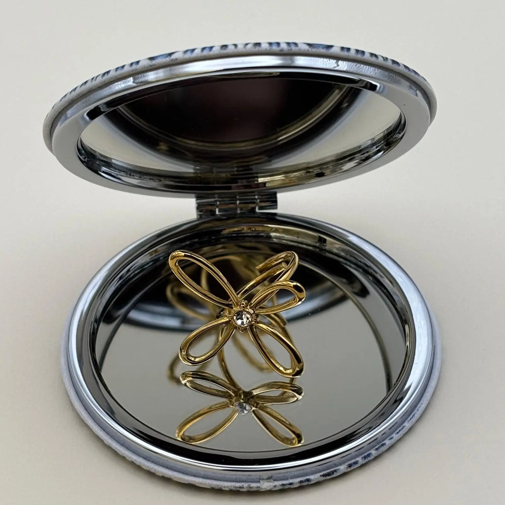 Bague dorée ajustable avec un motif de fleur a quatre pétales et strass en son centre