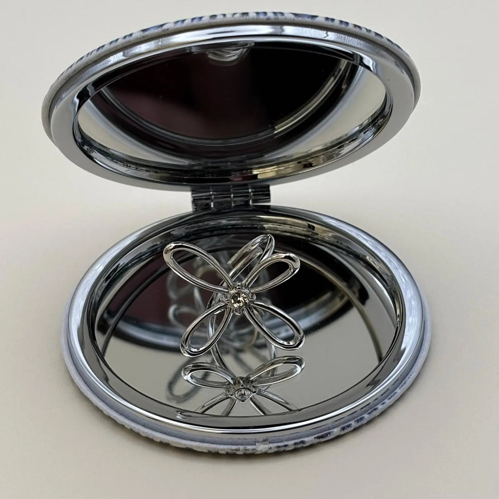 Bague de couleur argentée ajustable avec un motif de fleur a quatre pétales et strass en son centre