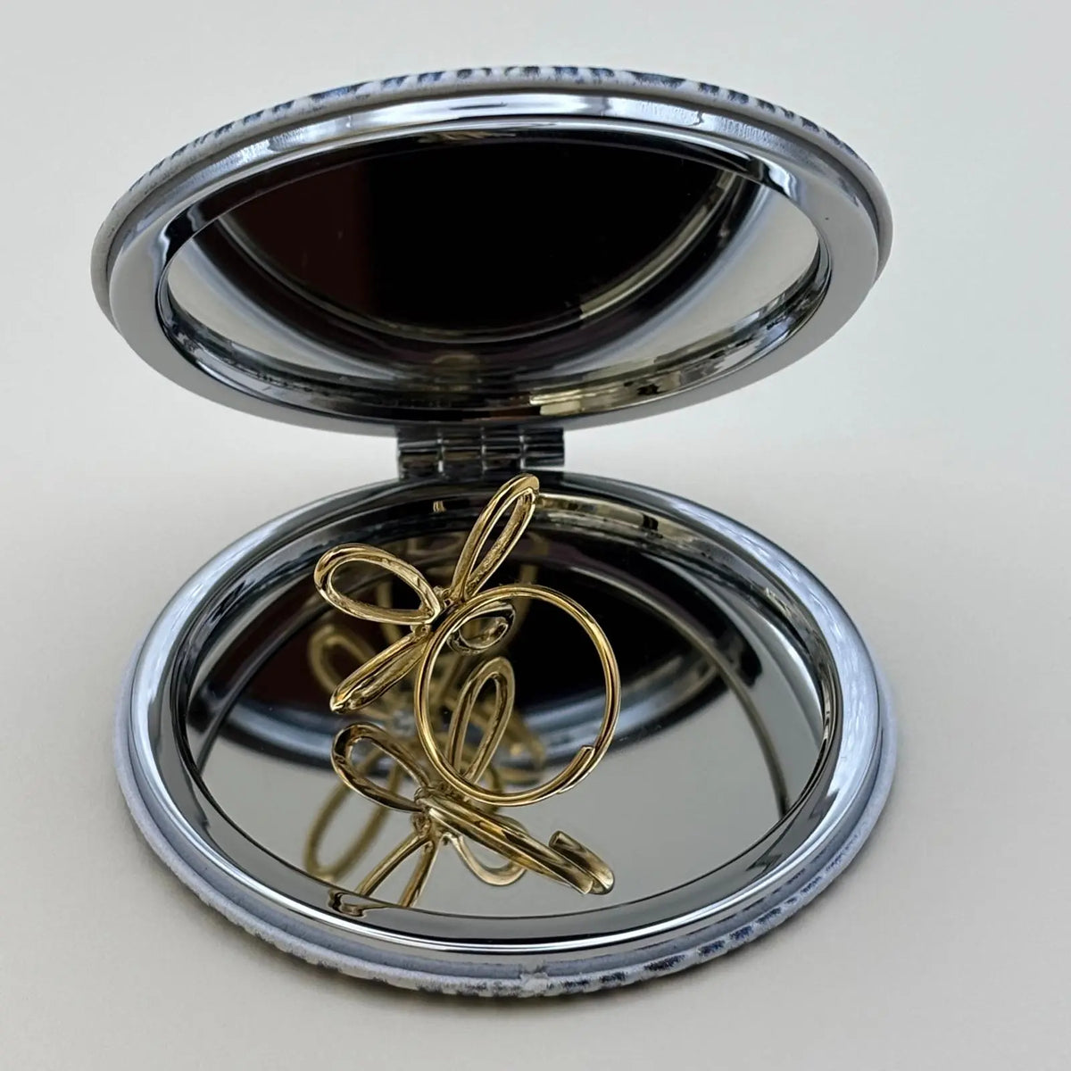 Bague dorée ajustable avec motif de fleur a quatre pétales et strass en son centre