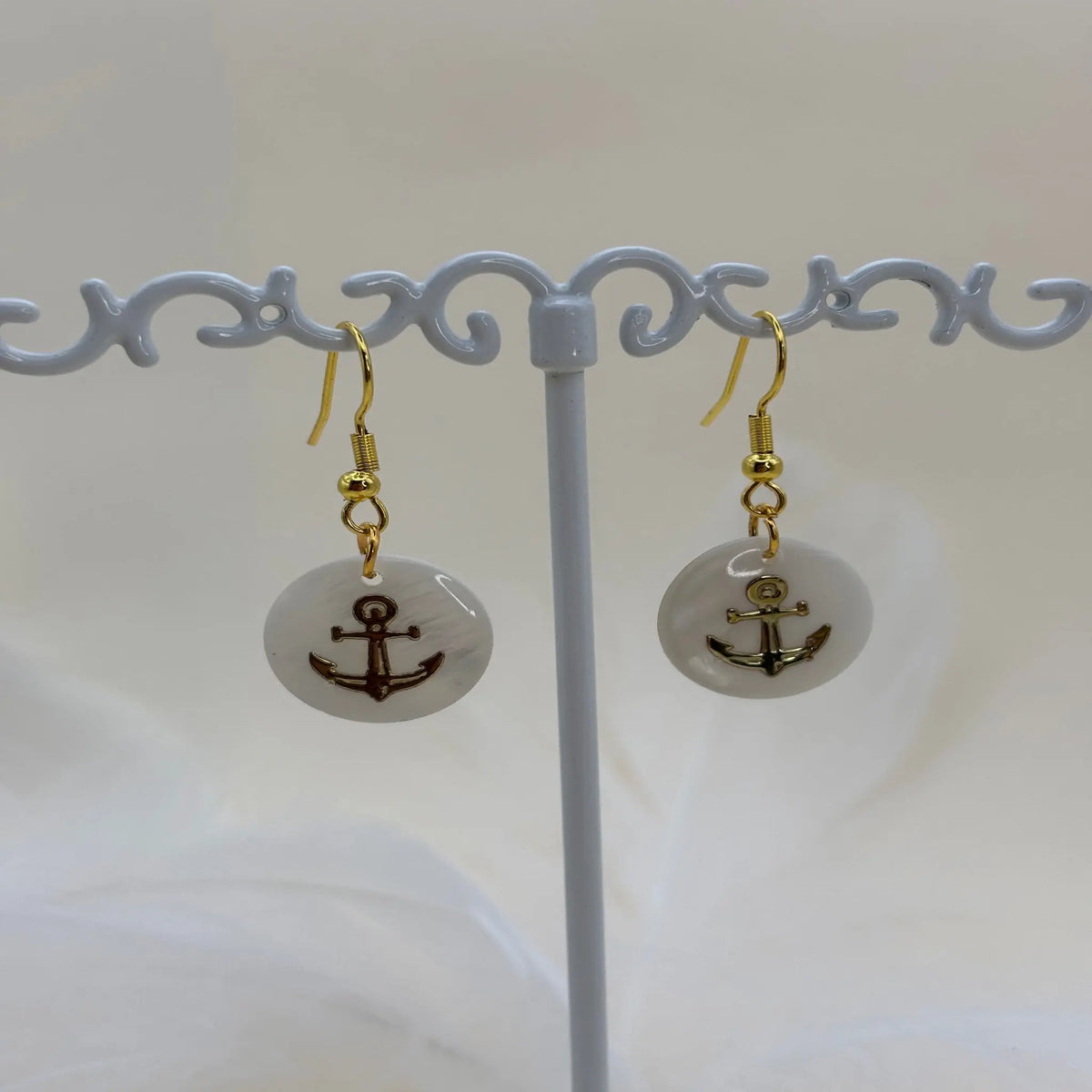 Paire de boucles d'oreilles avec une pastille nacrée et dessin d'une ancre de marine