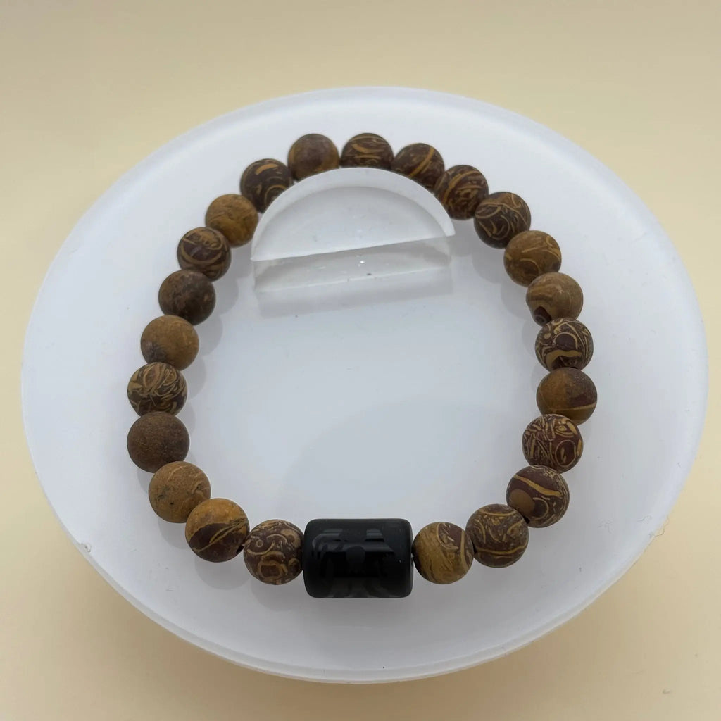 Bracelet alternant perles sombres et argentées, avec une perle centrale noire gravée