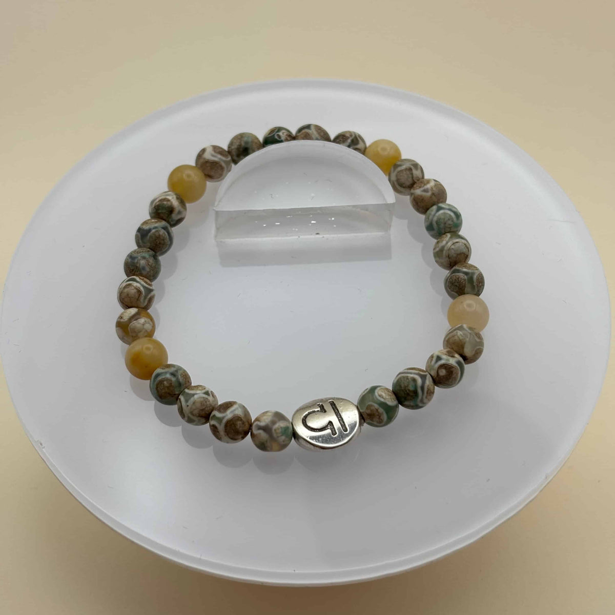 Un beau bracelet en perles sur élastique avec perles en porcelaine et en verre et médaillon avec le signe de la balance