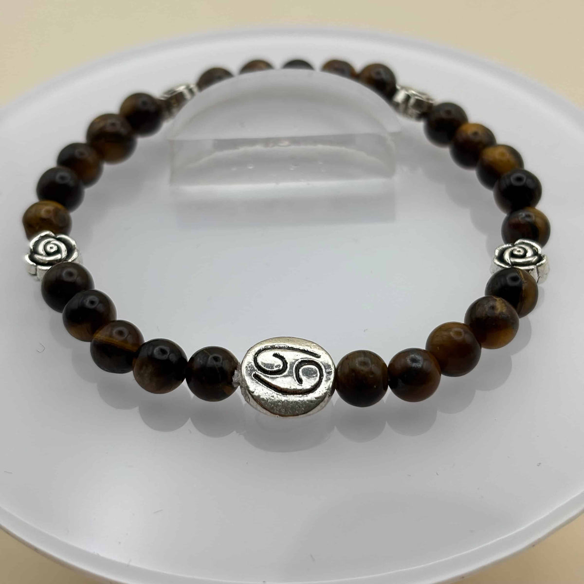 Un beau bracelet en perles sur élastique avec perles en porcelaine et en verre et médaillon avec le signe du cancer