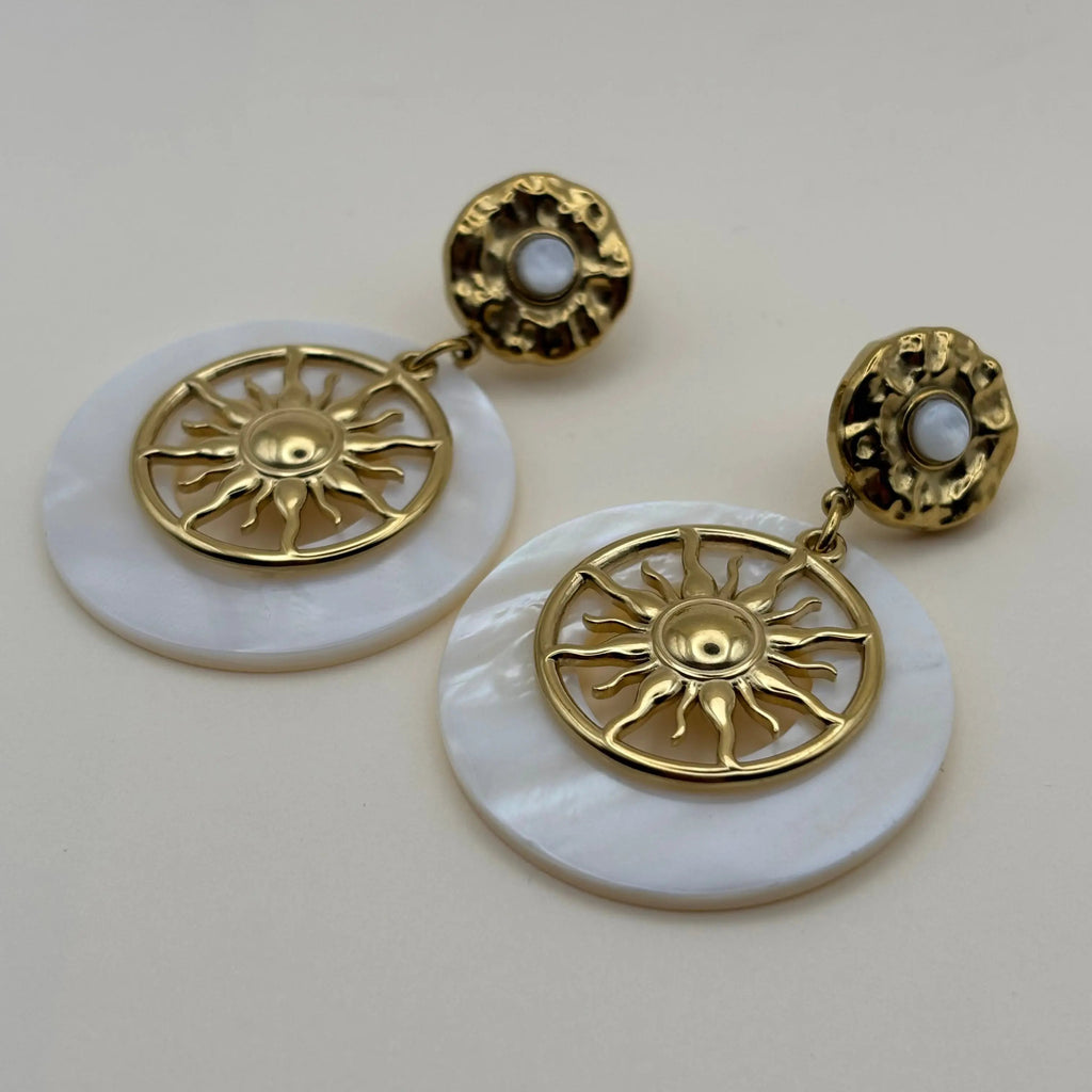 Boucles d'oreilles dorées avec cercle blanc en nacre et motif de soleil 