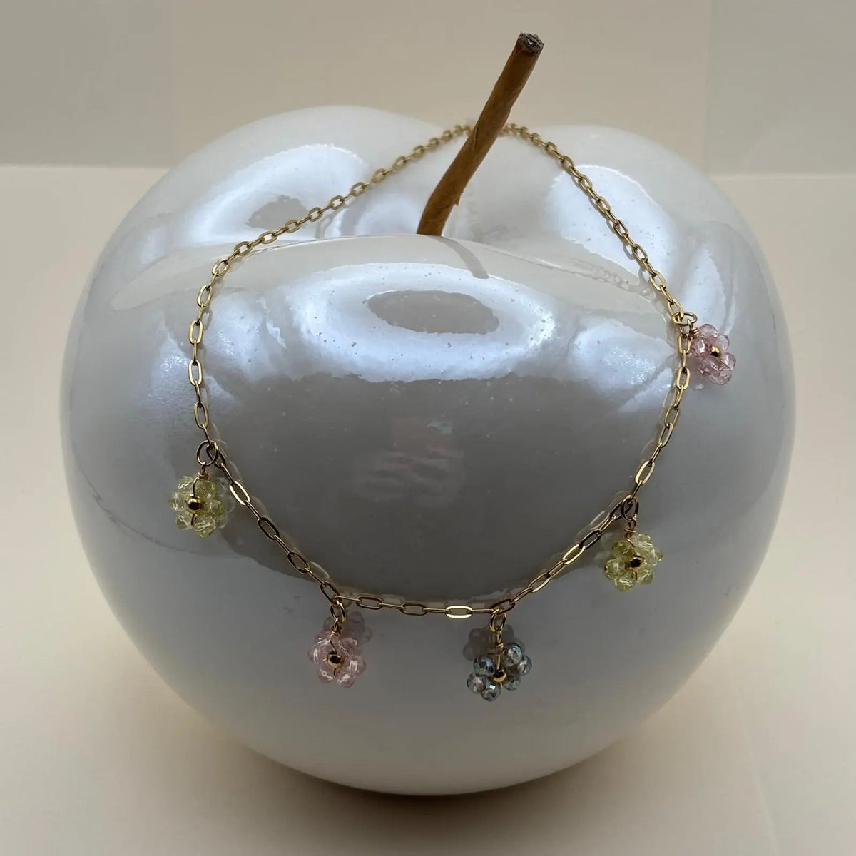 Un collier doré à fleurs en perles roses