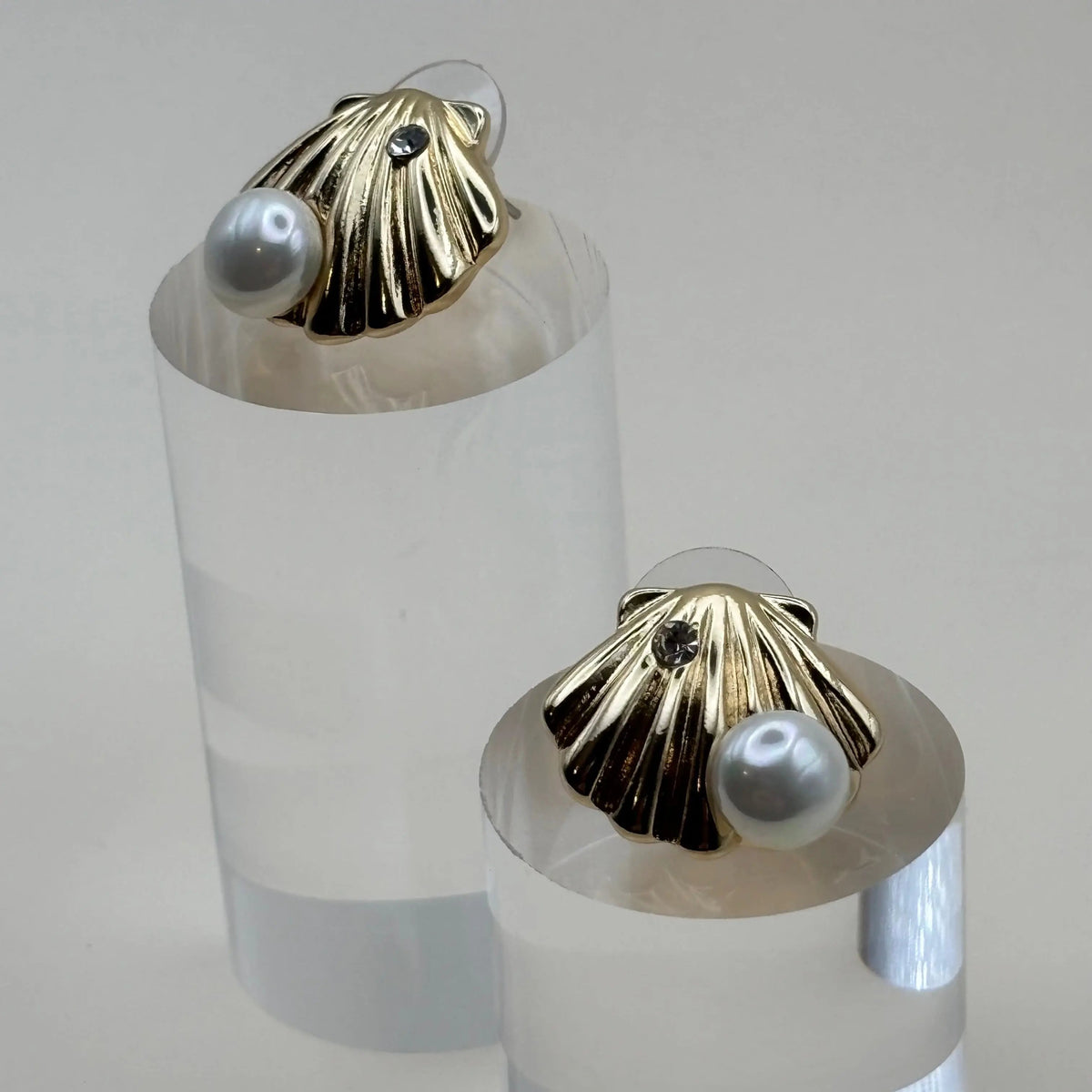 Des boucles d'oreilles dorées en forme de coquillage avec une perle argentée en acier inoxydable 