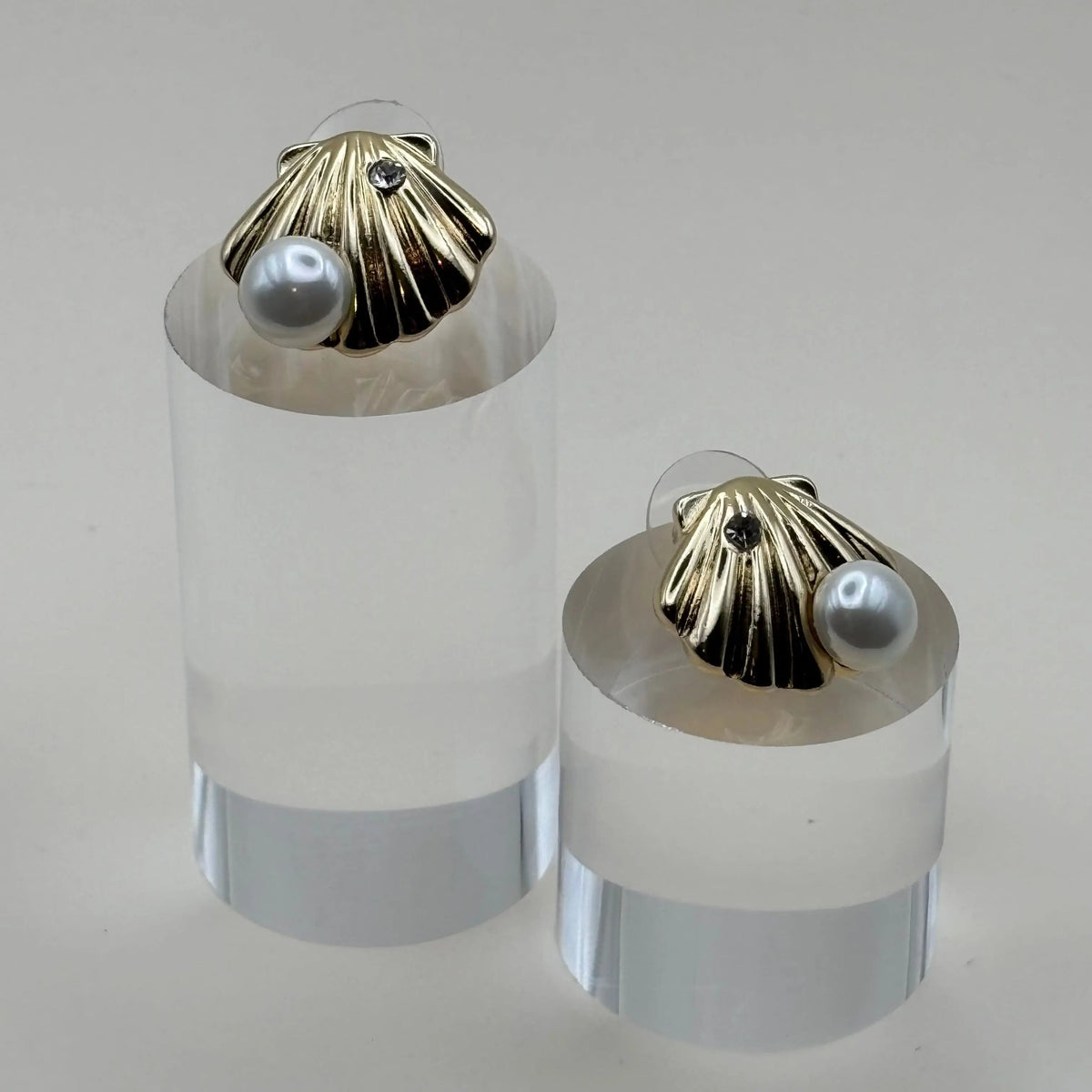 Une paire de boucles d'oreilles dorées en forme de coquillage avec une perle argentée en acier inoxydable 