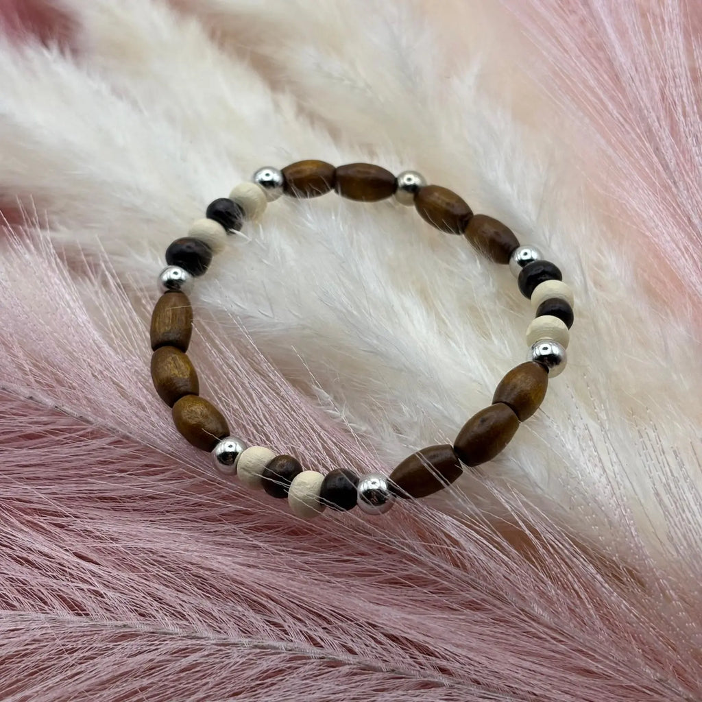 Vue de près d'un bracelet en perles artisanal avec perles de bois et perles acryliques allongées et rondes sur élastique