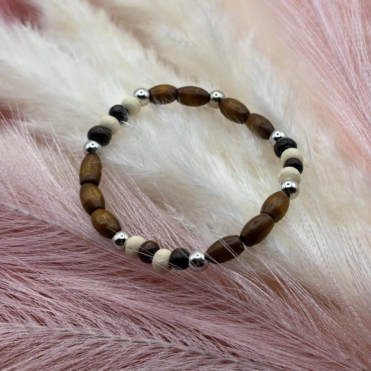 Vue de près d'un bracelet en perles artisanal avec perles de bois et perles acryliques allongées et rondes sur élastique