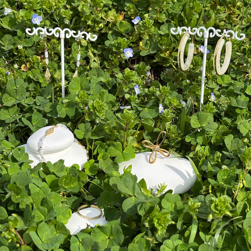 Des bagues et boucles d'oreilles fantaisie sur un lit de trèfles