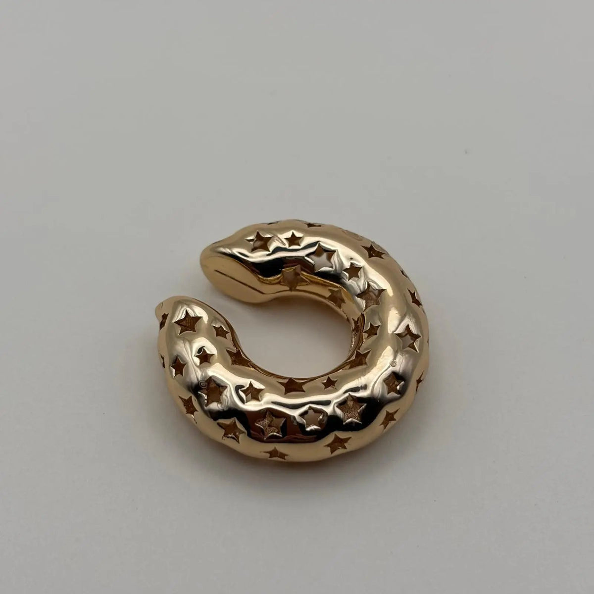 Une boucle d'oreille doré pour cartilage avec motifs étoiles en acier inoxydable