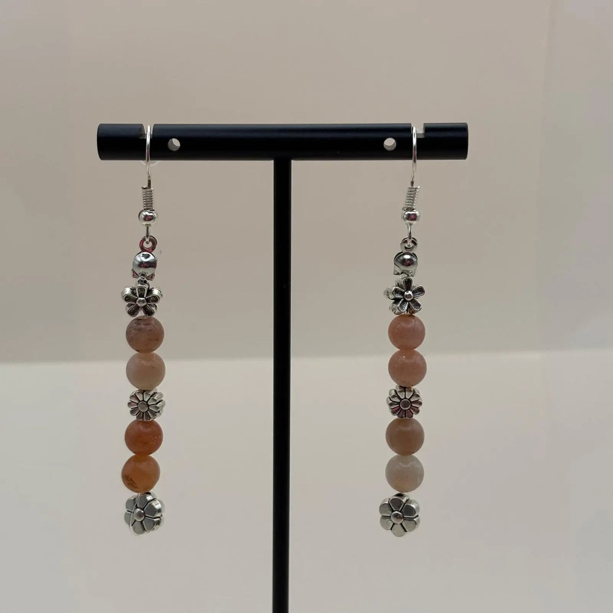 Des boucles d’oreilles pendantes avec attache argentée avec breloques en forme de fleurs et perles acryliques