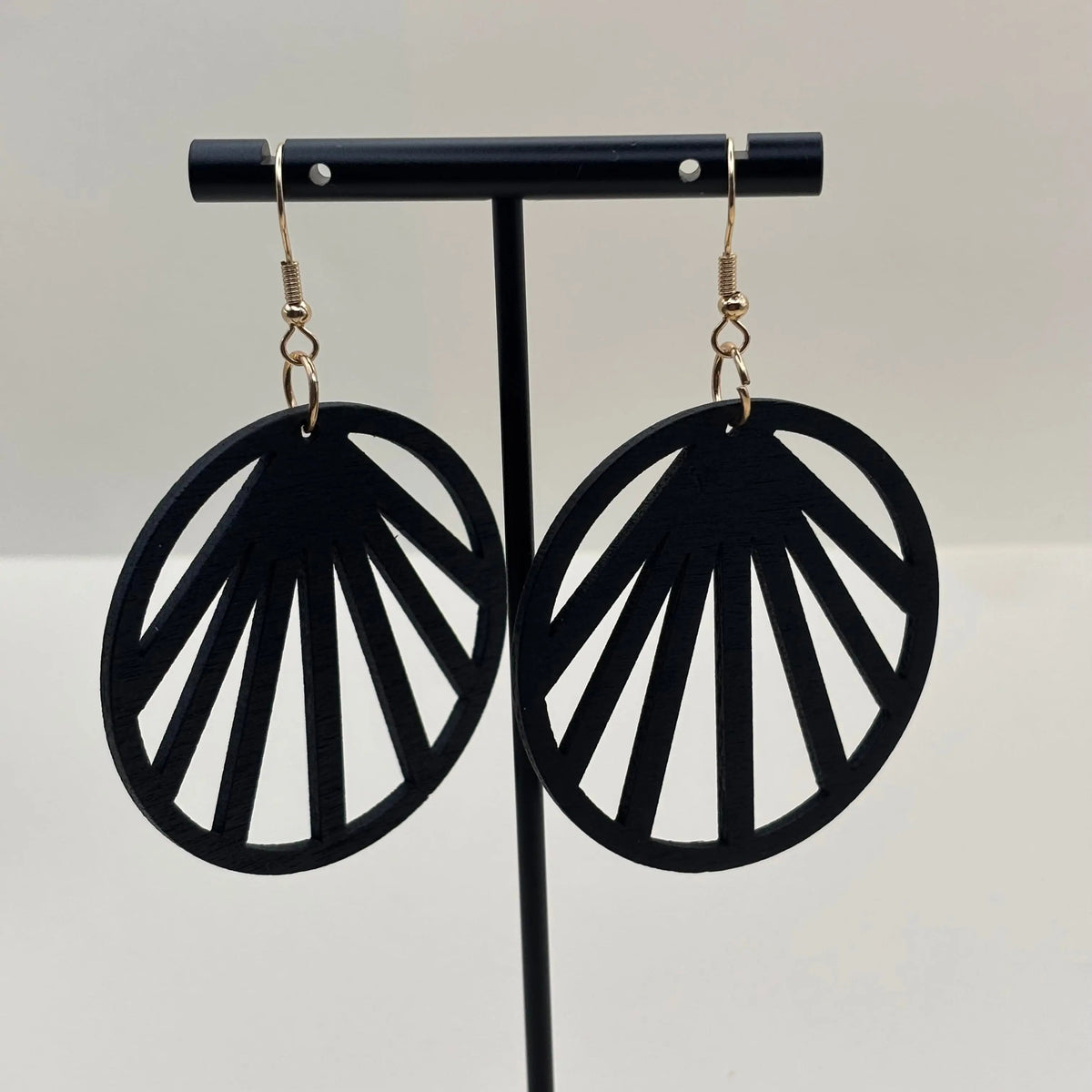 Boucles d'oreilles attache dorée et boucle en bois léger noire avec des motifs géométriques