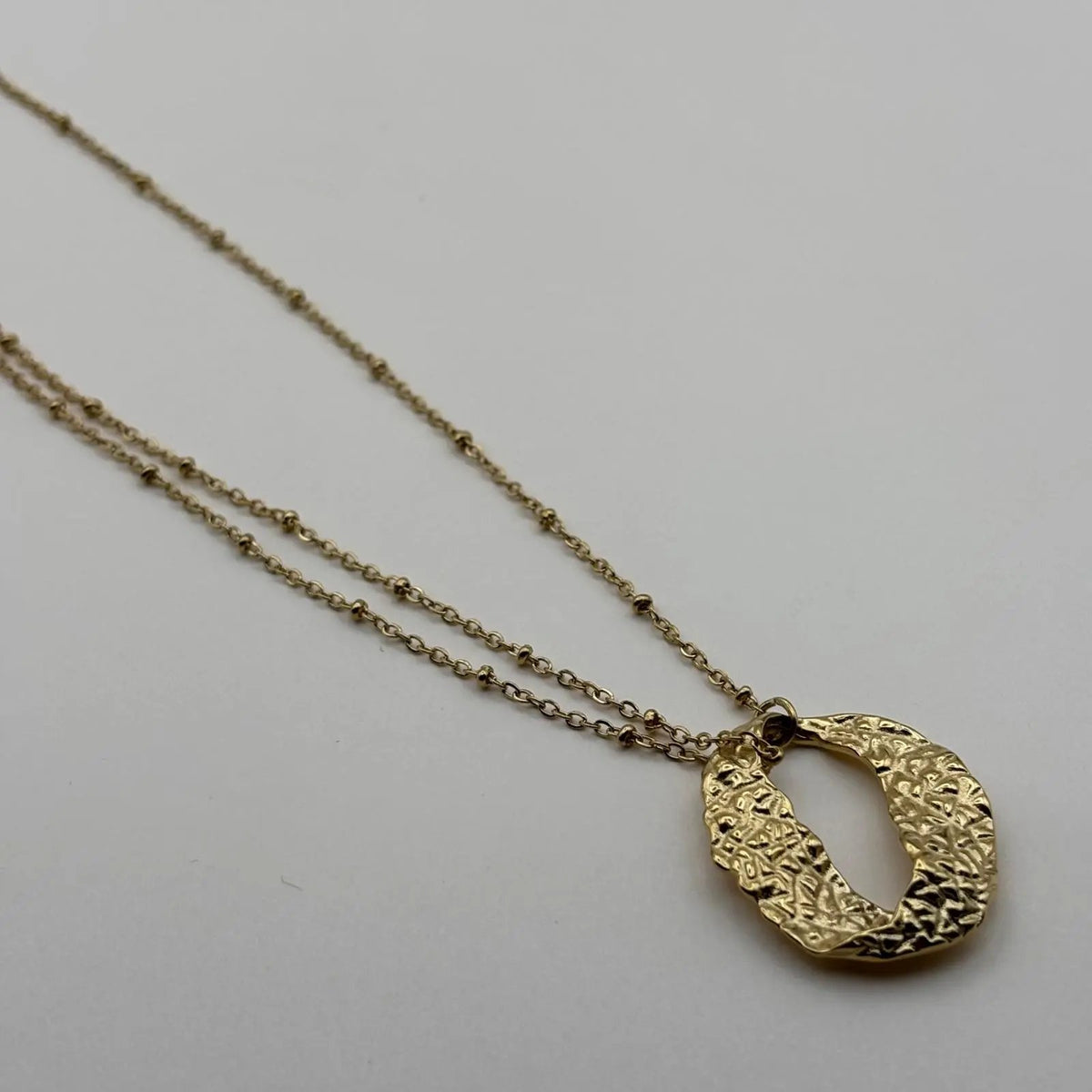 Un collier doré avec pendentif cercle doré en acier inoxydable