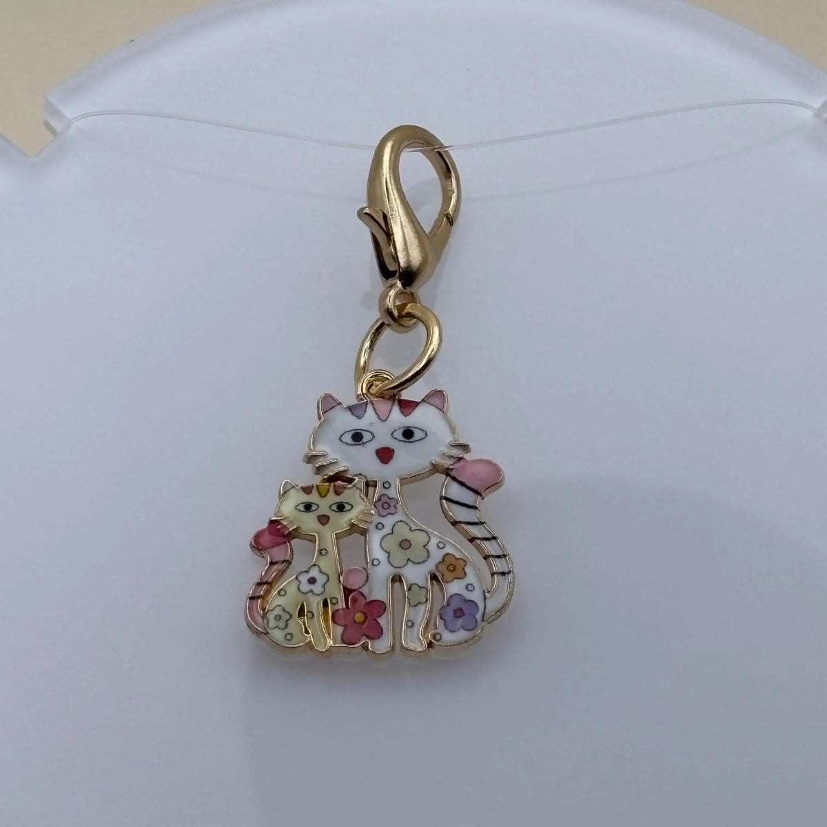 Bijou à accrocher en acier représentant une maman chat blanche entourée de ses chatons colorés, symbole d’amour familial et de tendresse féline.