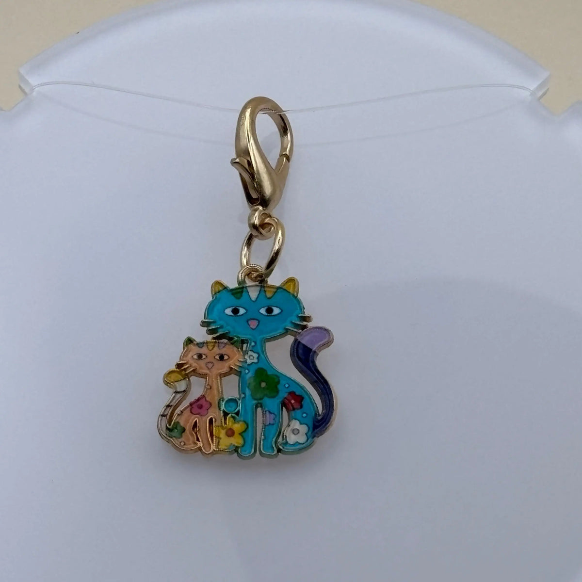 Bijou à accrocher en acier représentant une maman chat bleue entourée de ses chatons colorés, symbole d’amour familial et de tendresse féline.