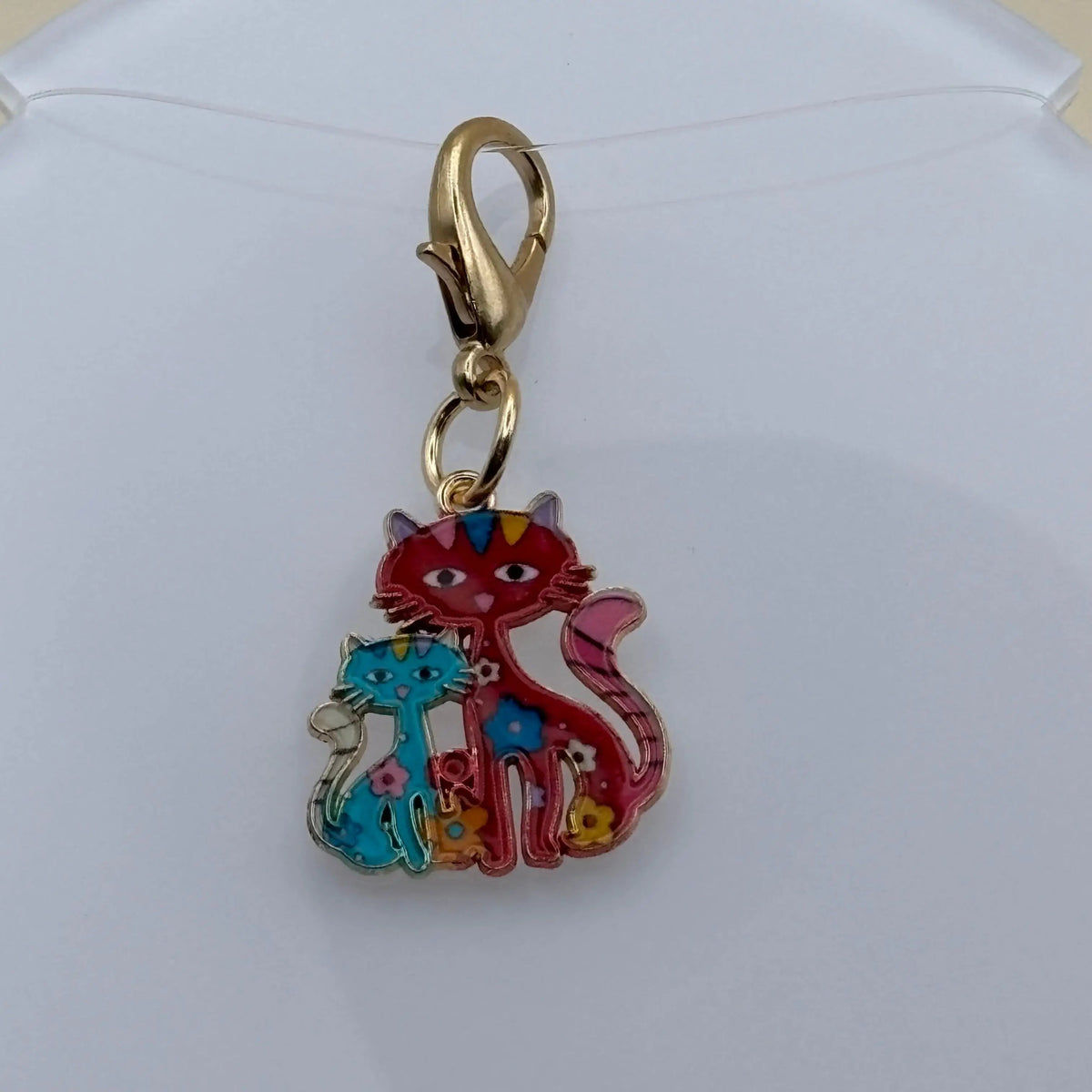 Bijou à accrocher en acier représentant une maman chat rouge entourée de ses chatons colorés, symbole d’amour familial et de tendresse féline.