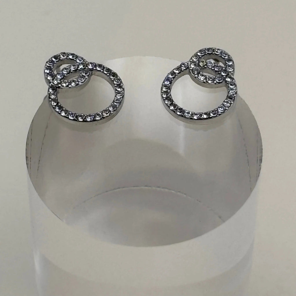 Une paire de boucles d'oreilles argentées avec des petits anneaux avec strass argenté en acier inoxydable