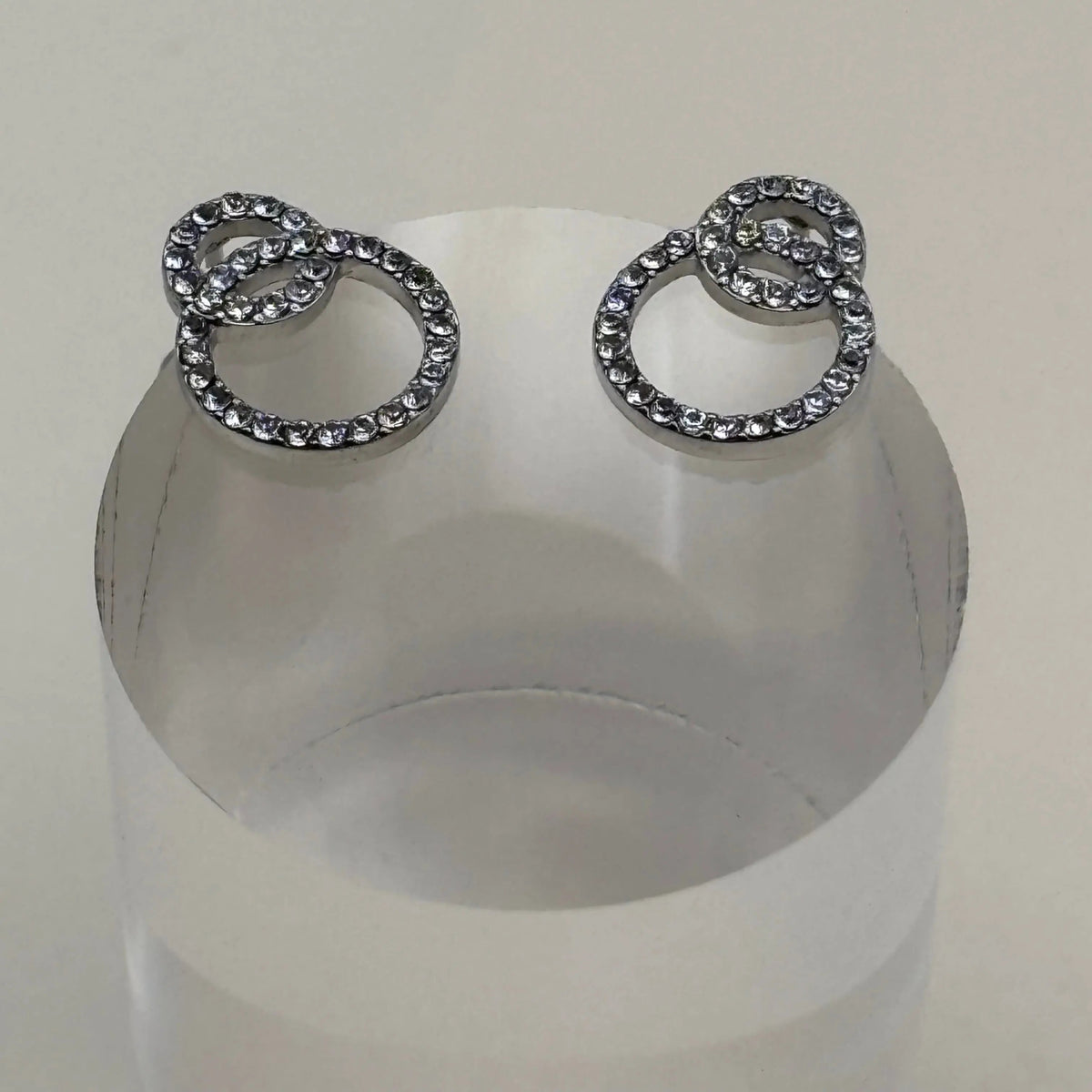 Une paire de boucles d'oreilles argentées avec des petits anneaux avec strass argenté en acier inoxydable