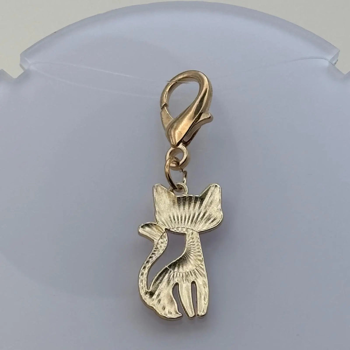 Dos d'un bijoux à accrocher en forme de chat avec une tête orange et anneau doré