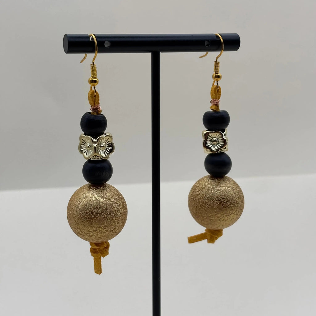 Boucles d'oreilles en forme de pendentif avec une perle dorée et des perles bois et acryliques noires et dorées 
