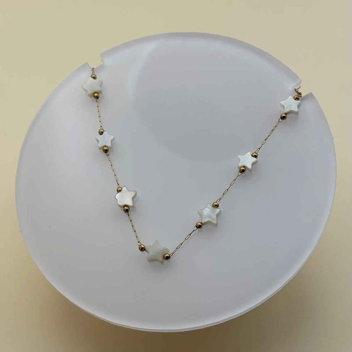 Bracelet doré à petits maillons avec breloques en forme d'étoiles blanches 