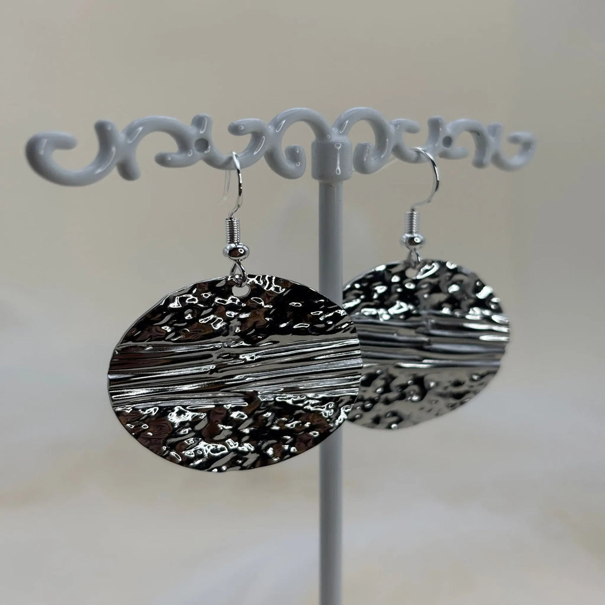 Une paire de boucles d'oreilles argentées avec pastille coucher de soleil