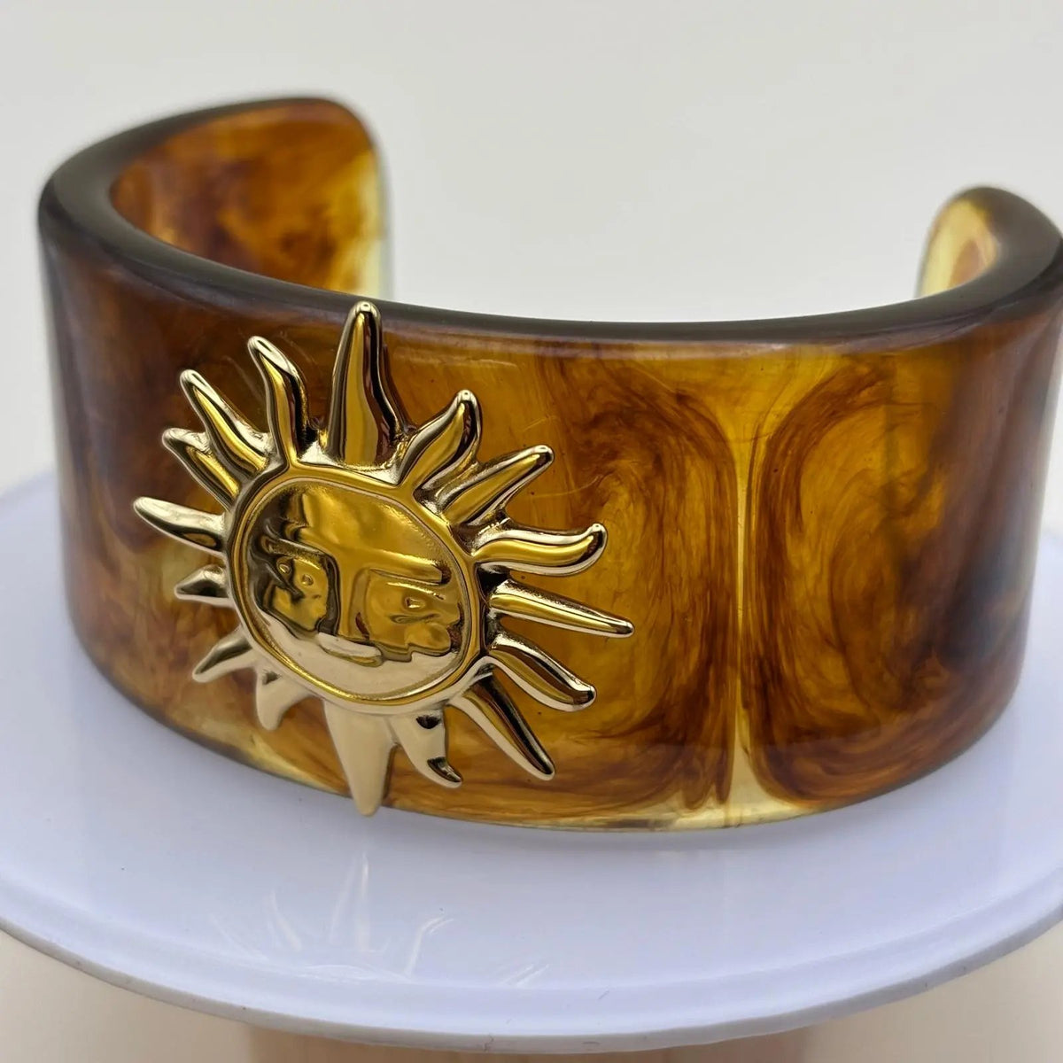 Bracelet rigide en acrylique marron avec un motif soleil doré