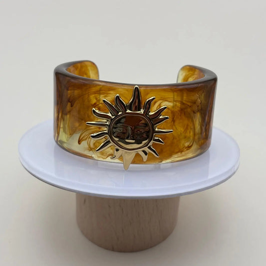 Bracelet rigide en acrylique marron avec un motif soleil doré