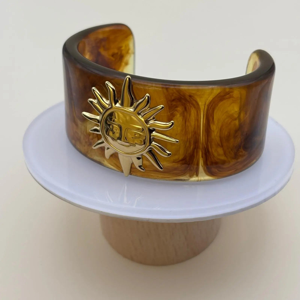 Bracelet rigide en matière acrylique marron avec un motif soleil doré