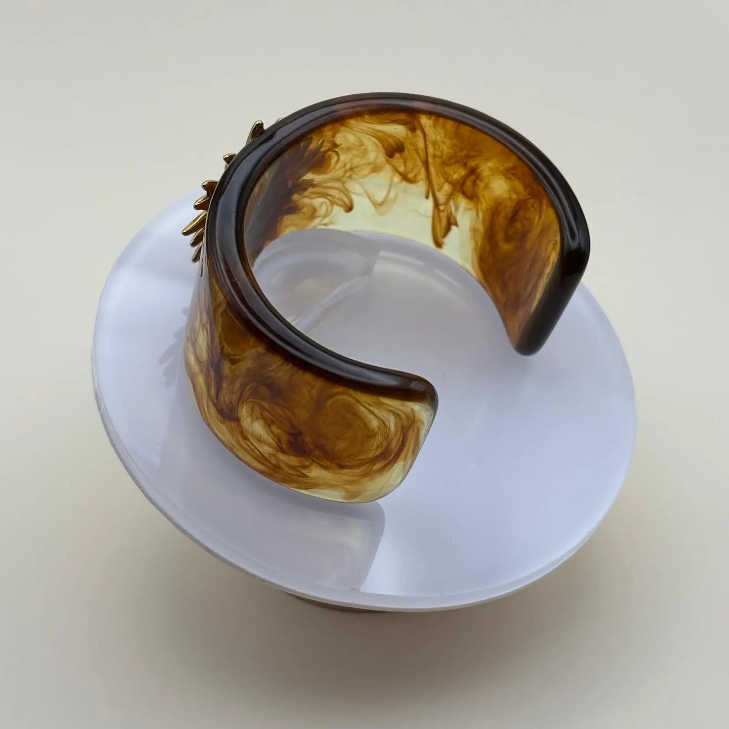 Bracelet rigide en matière acrylique marron avec un motif soleil doré