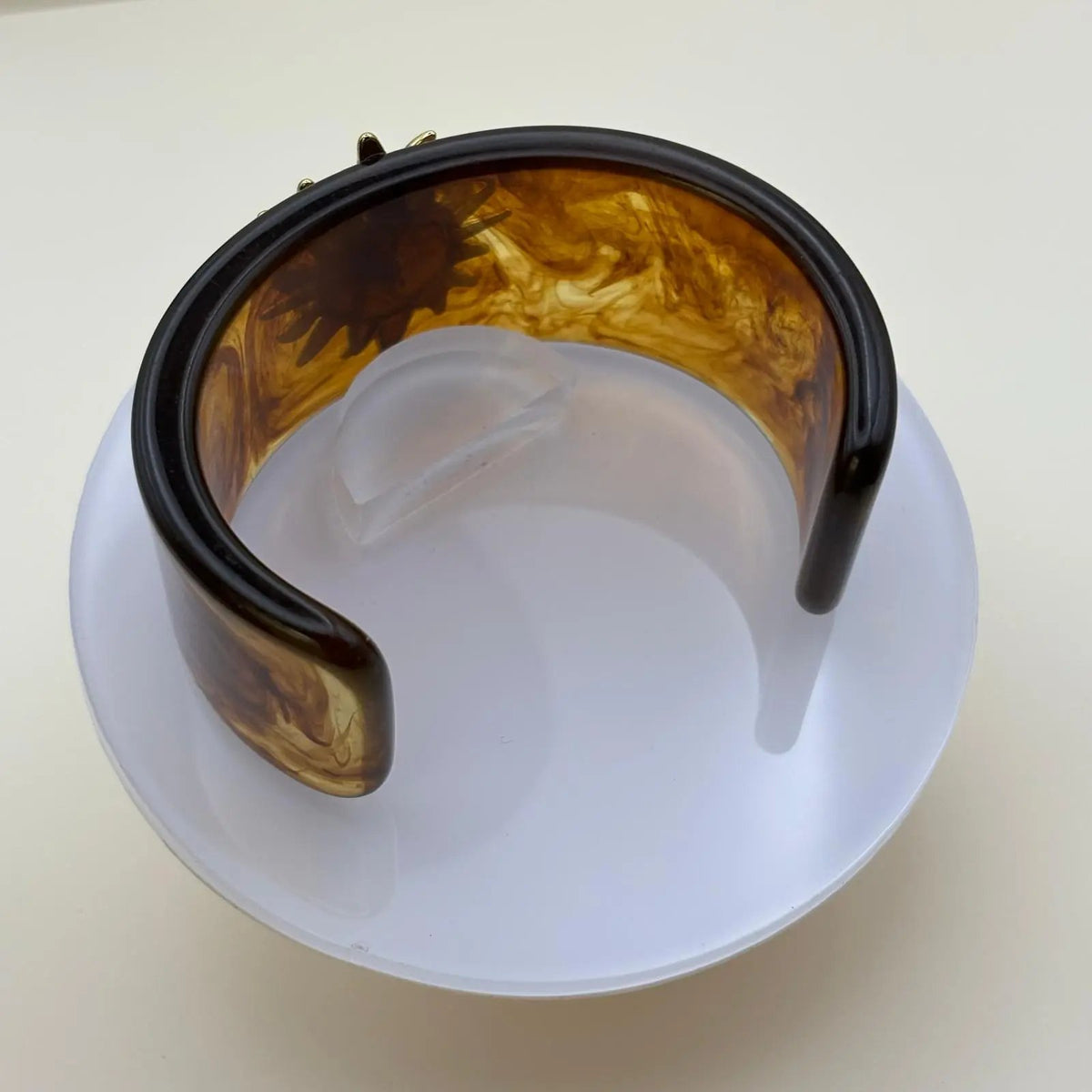 Bracelet rigide en acrylique marron avec un motif en forme de soleil doré