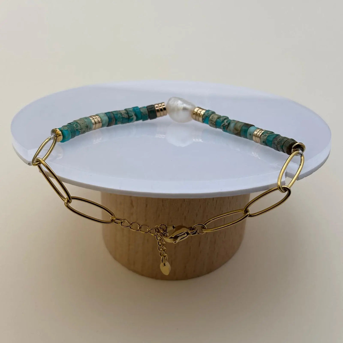 Bracelet doré avec des perles acryliques bleues et une perle nacrée au centre maillons allongés