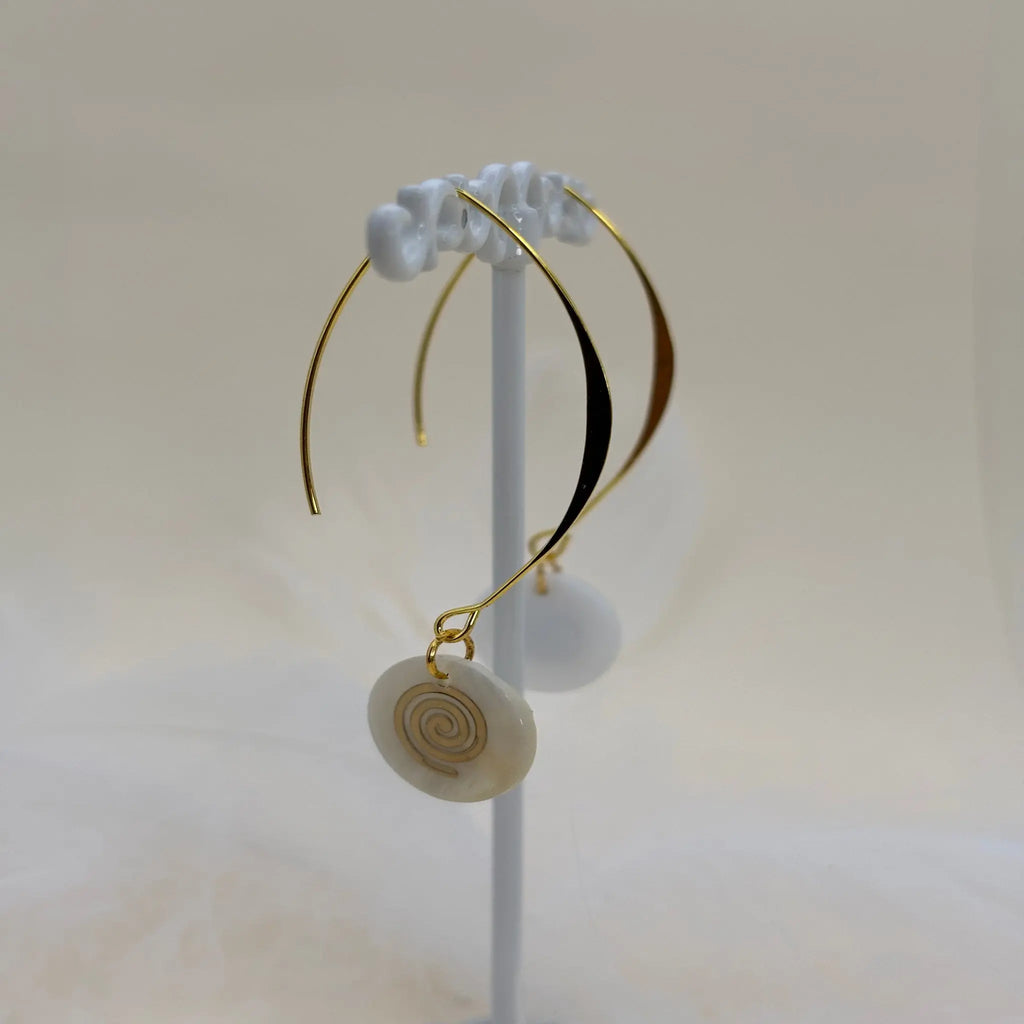 Un paire de boucles d'oreilles pendentif avec une pastille nacrée et dessin de spirale