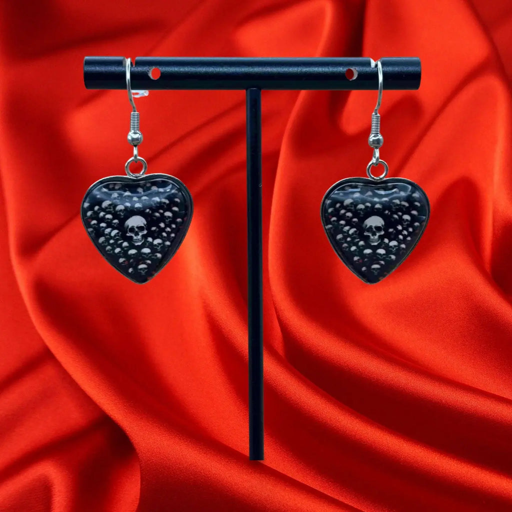 Boucles d'oreilles pendentif halloween en forme de coeur avec fond noir et tete de mort vendues sur le site pretes a briller