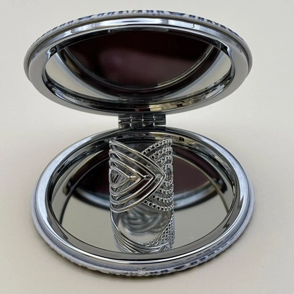 Bague argentée ajustable avec des motifs géométriques en forme de volutes 