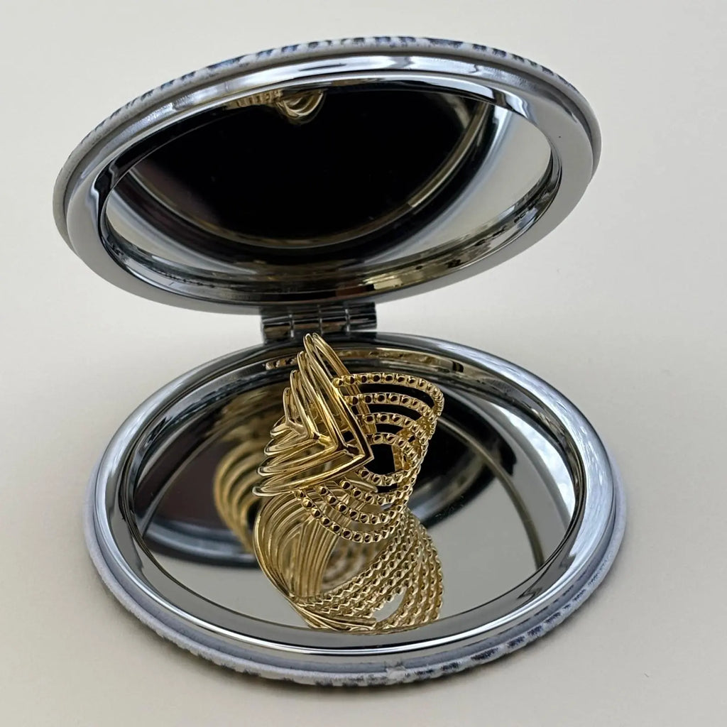 Bague dorée ajustable avec des motifs géométriques en forme de volutes 